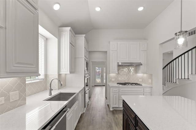 kitchen featuring white cabinets, hanging light fixtures, a healthy amount of sunlight, and sink