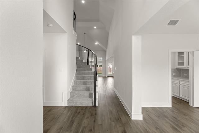 corridor featuring dark hardwood / wood-style floors and a high ceiling