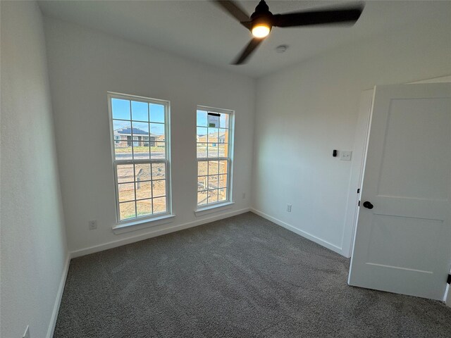 carpeted spare room featuring ceiling fan