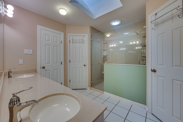 bathroom with tile patterned floors, vanity, a skylight, and a shower with shower door