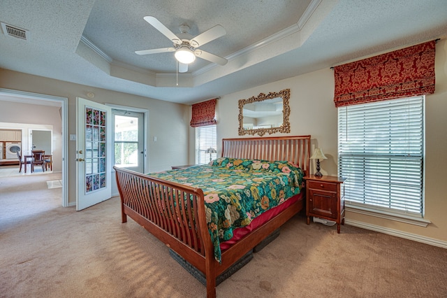 carpeted bedroom with ceiling fan, access to exterior, a raised ceiling, and ornamental molding