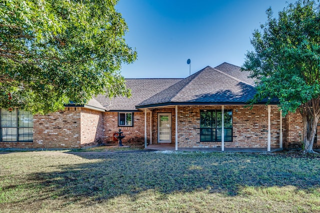 ranch-style house featuring a front lawn and a patio area