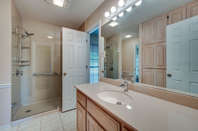 bathroom featuring a textured ceiling, tile patterned flooring, vanity, and an enclosed shower