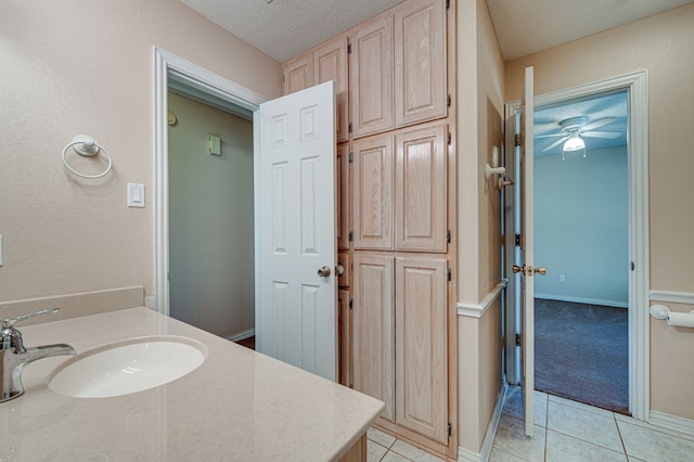 bathroom with vanity, a textured ceiling, ceiling fan, and tile patterned floors