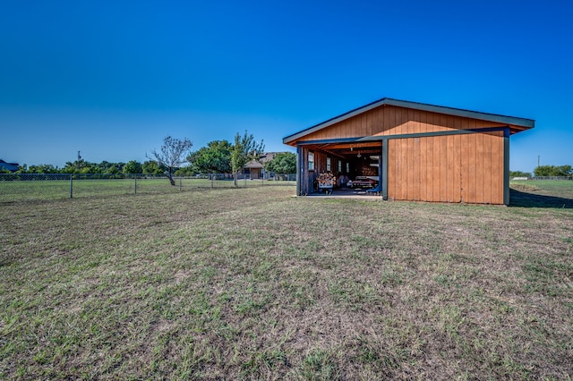 view of yard featuring a rural view and an outbuilding