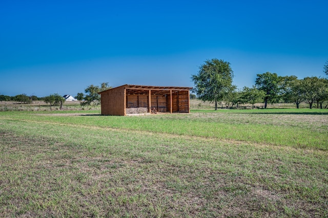 view of yard with an outdoor structure and a rural view