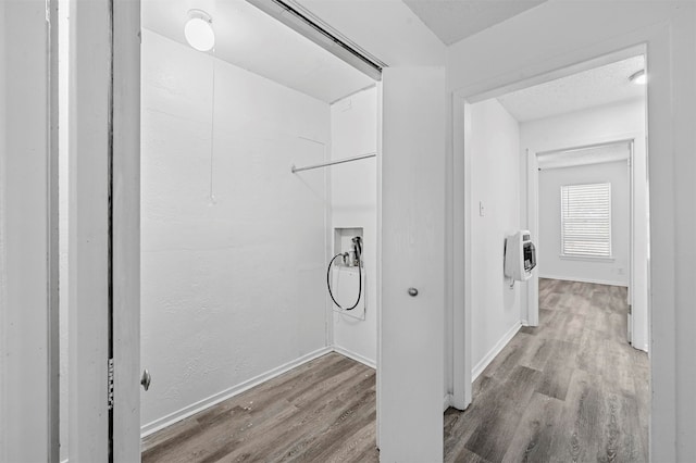 laundry area with hookup for a washing machine, light hardwood / wood-style floors, and heating unit