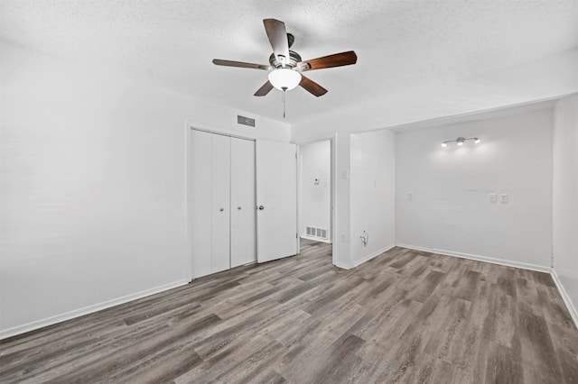 spare room featuring ceiling fan, hardwood / wood-style flooring, and a textured ceiling