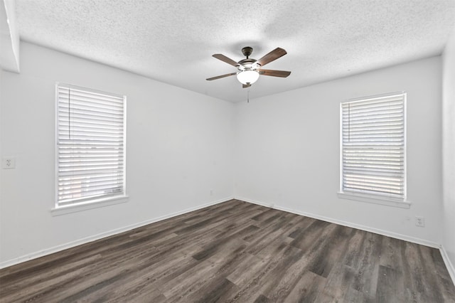 empty room featuring ceiling fan, a textured ceiling, and dark wood-type flooring