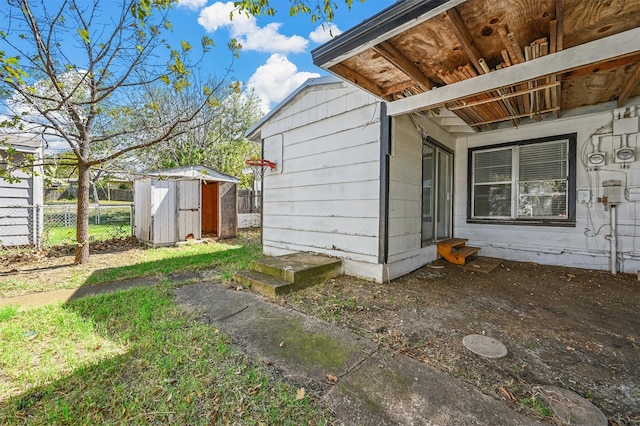 view of side of home featuring a storage shed