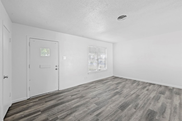 foyer entrance featuring a textured ceiling, hardwood / wood-style flooring, and a wealth of natural light