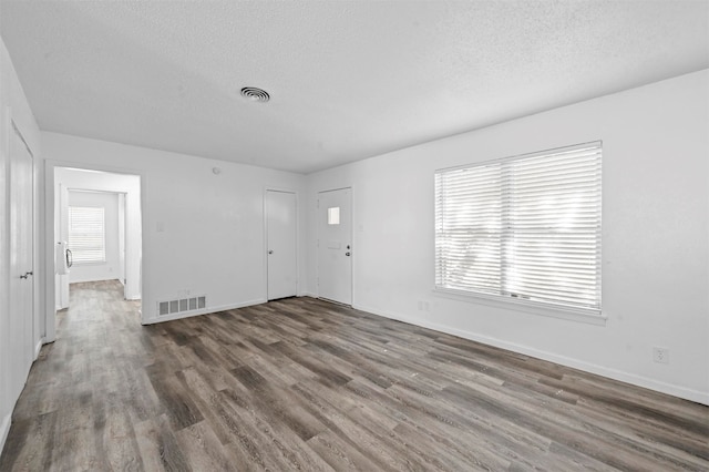 unfurnished room featuring hardwood / wood-style flooring and a textured ceiling