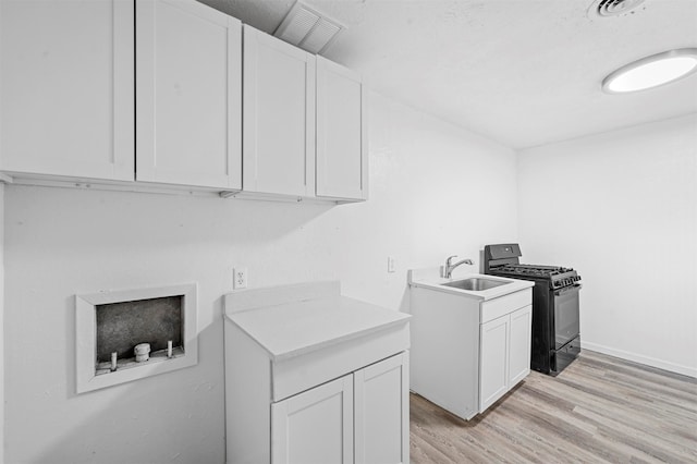 laundry room featuring light hardwood / wood-style floors and sink