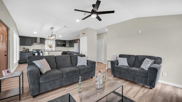 living room featuring ceiling fan, lofted ceiling, and light hardwood / wood-style flooring