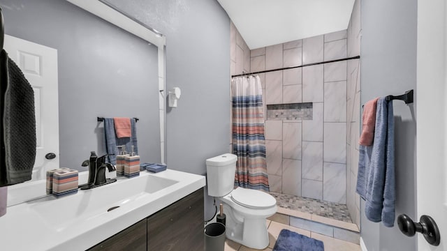 bathroom with toilet, tile patterned floors, tiled shower, and vanity