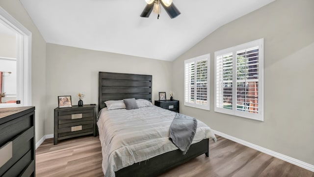 bedroom featuring ceiling fan, light wood-type flooring, and lofted ceiling