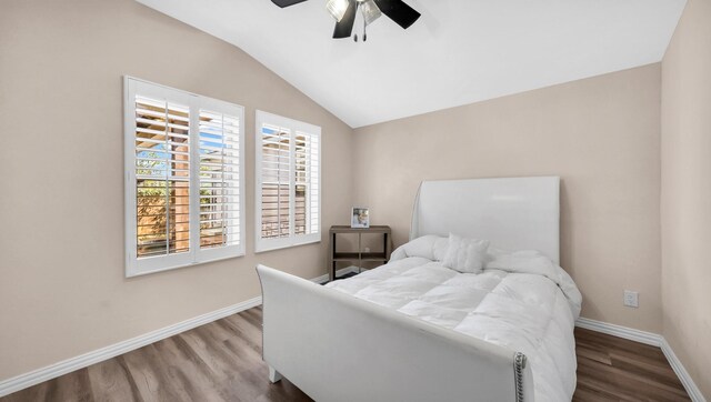 bedroom with vaulted ceiling, ceiling fan, wood finished floors, and baseboards