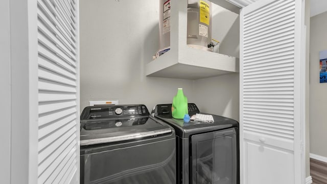 clothes washing area with baseboards, laundry area, and washer and dryer