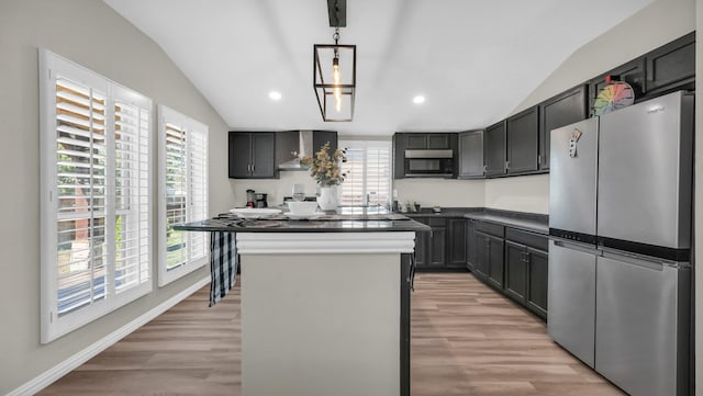 kitchen featuring stainless steel appliances, dark countertops, light wood-style floors, and lofted ceiling