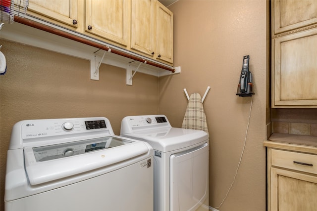 washroom with cabinets and washer and dryer