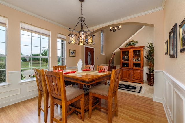 dining area featuring ornamental molding, a notable chandelier, and light hardwood / wood-style floors