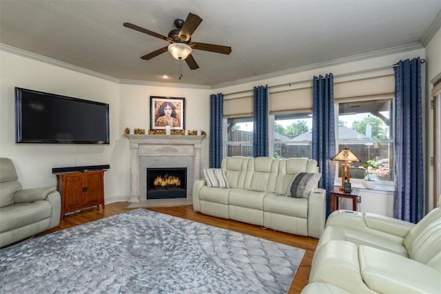 living room featuring ornamental molding, wood-type flooring, ceiling fan, and a textured ceiling