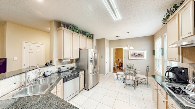 kitchen with pendant lighting, sink, stainless steel appliances, backsplash, and a textured ceiling