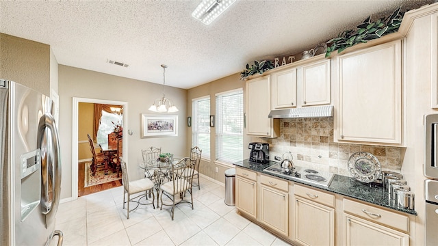 kitchen featuring pendant lighting, stainless steel fridge with ice dispenser, white electric stovetop, and a textured ceiling