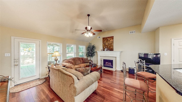 living room featuring vaulted ceiling, dark hardwood / wood-style flooring, a wealth of natural light, and ceiling fan