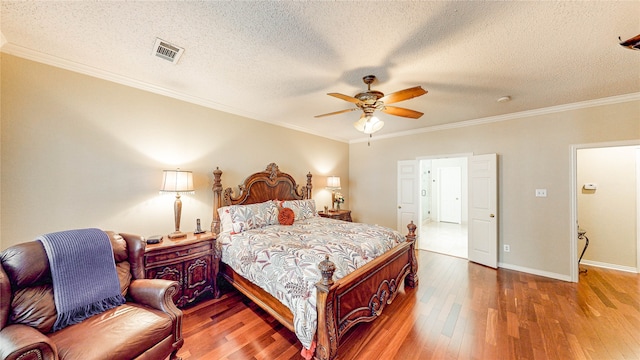 bedroom featuring ornamental molding, hardwood / wood-style flooring, a textured ceiling, and ceiling fan