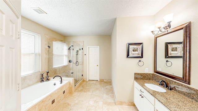 bathroom with tile patterned flooring, vanity, independent shower and bath, and a textured ceiling