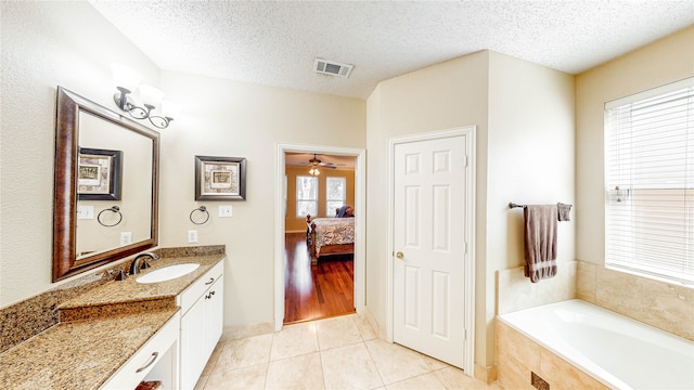 bathroom featuring vanity, a textured ceiling, and a healthy amount of sunlight