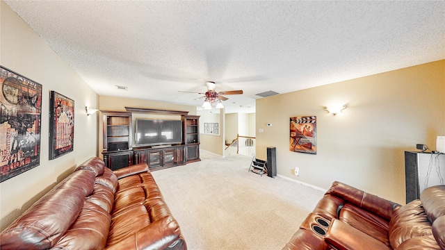 living room featuring ceiling fan, a textured ceiling, and carpet flooring