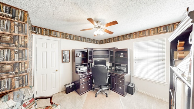 carpeted office with a textured ceiling and ceiling fan