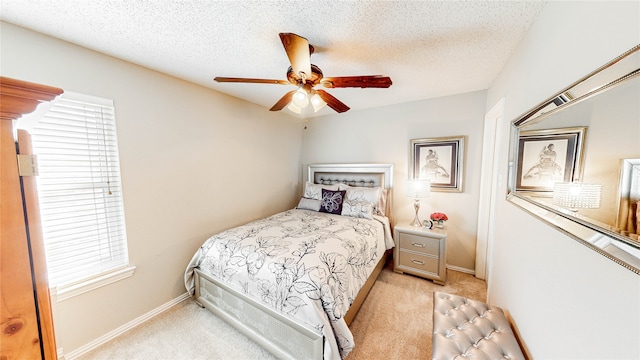 carpeted bedroom with ceiling fan and a textured ceiling