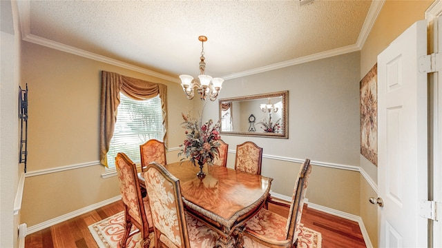 dining space with ornamental molding, hardwood / wood-style floors, a chandelier, and a textured ceiling