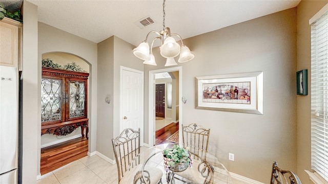 dining room with light hardwood / wood-style floors and an inviting chandelier