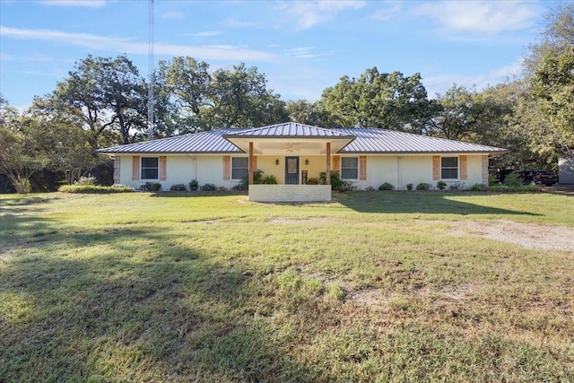 view of front of property featuring metal roof, a standing seam roof, and a front lawn