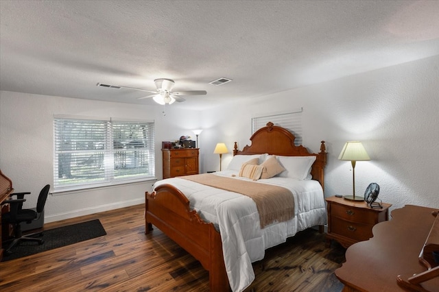 bedroom with ceiling fan, a textured ceiling, and dark wood-type flooring