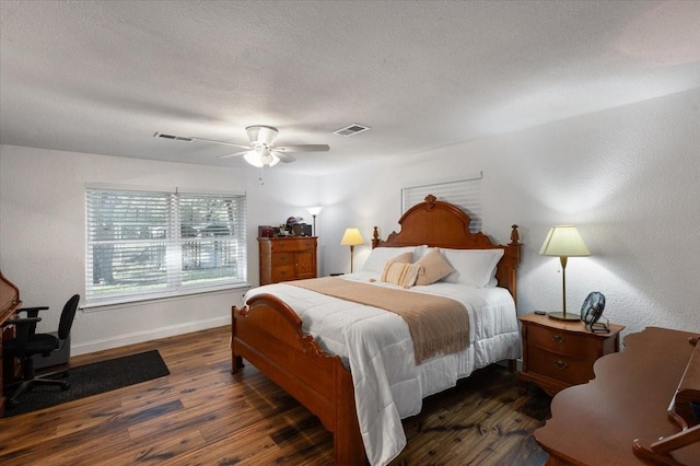bedroom featuring a textured ceiling, wood finished floors, baseboards, and visible vents