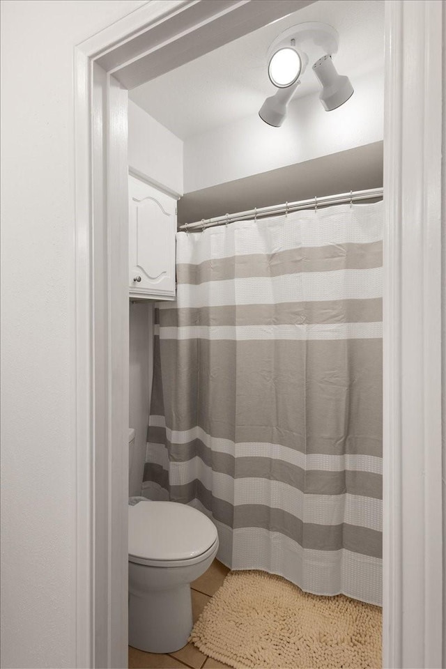 full bath with toilet, tile patterned flooring, and a shower with curtain