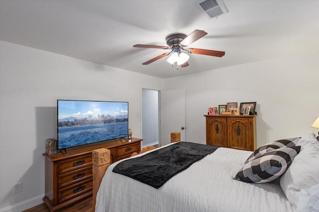 bedroom with visible vents, baseboards, a ceiling fan, and wood finished floors