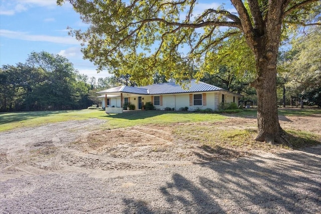 single story home with a front yard and metal roof