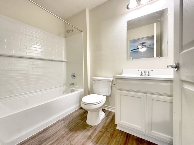 full bathroom with ceiling fan, vanity, toilet, tiled shower / bath combo, and hardwood / wood-style floors