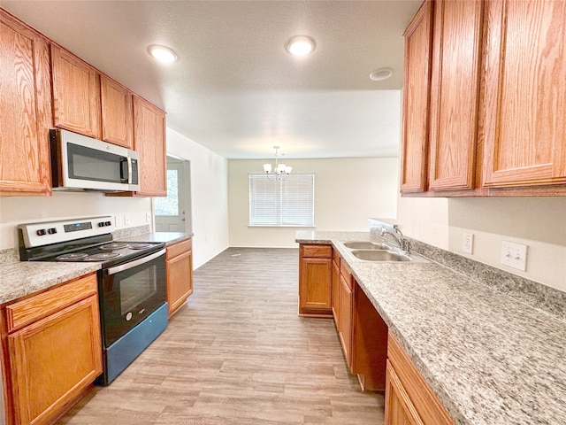 kitchen with a chandelier, light hardwood / wood-style floors, sink, hanging light fixtures, and appliances with stainless steel finishes