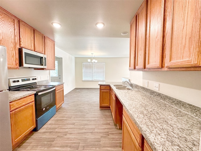 kitchen with sink, decorative light fixtures, stainless steel appliances, a notable chandelier, and light wood-type flooring