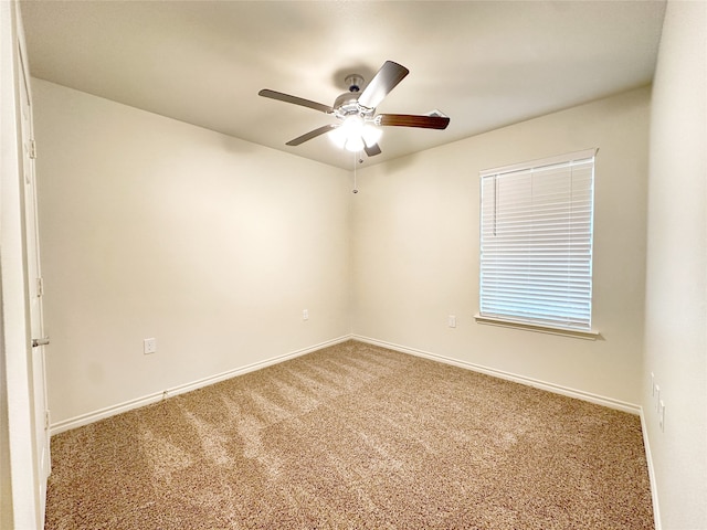 carpeted spare room featuring ceiling fan