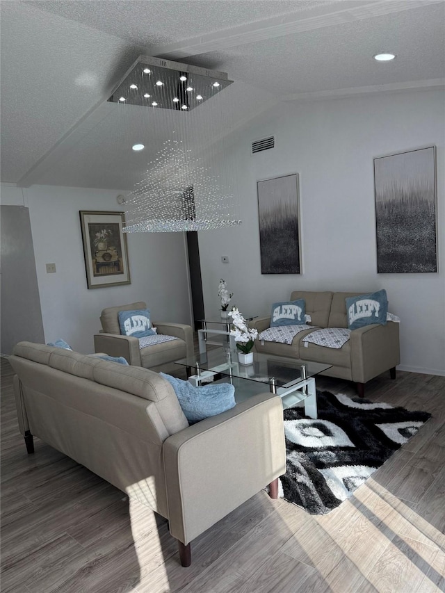 living room with a textured ceiling, wood-type flooring, and lofted ceiling