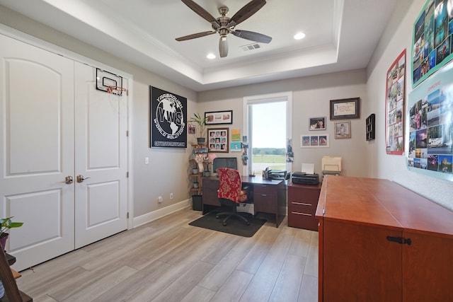 office with light hardwood / wood-style flooring, ceiling fan, a raised ceiling, and ornamental molding