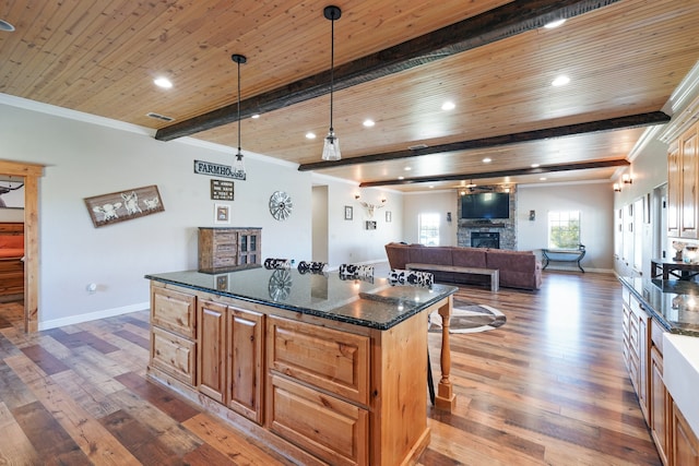 kitchen with dark stone countertops, a fireplace, dark hardwood / wood-style flooring, and wooden ceiling